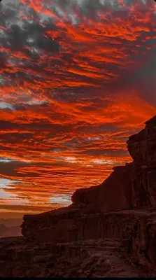 a sunset in the desert with a cloudy sky at Wadi rum Moon Iight Camp in Wadi Rum