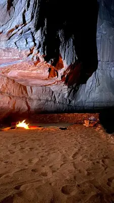 a cave with a fire inside of it at Wadi rum Moon Iight Camp in Wadi Rum