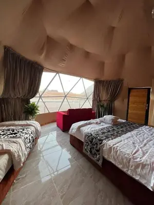 a bedroom with two beds and a large window at Rum Rayan magic camp in Wadi Rum