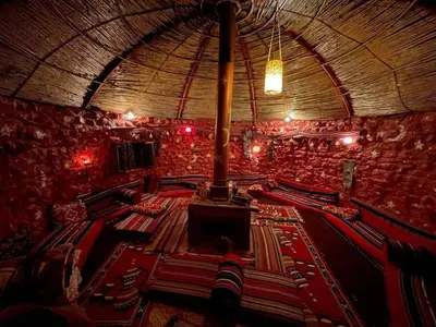 a large auditorium with red chairs and a ceiling at Petra Bedouin House 1 Attallah guest house in Wadi Musa