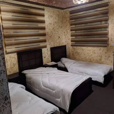 a room with three beds in a room with a wall at Petra Bedouin House 1 Attallah guest house in Wadi Musa