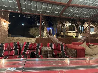 a living room with red couches and a hammock at Petra Bedouin House 1 Attallah guest house in Wadi Musa