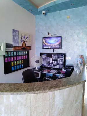 a bar in a salon with a desk and a tv at Baraka Al Aqaba Hotel Suites in Aqaba