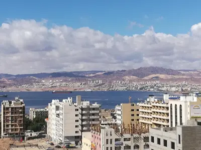 a city with buildings and a body of water at Baraka Al Aqaba Hotel Suites in Aqaba