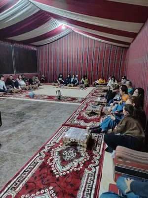 a group of people sitting in a room with carpets at Bubble RumCamp in Wadi Rum
