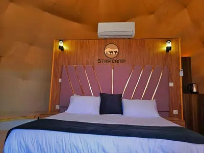 a bedroom with a bed with a wooden head board at Star Camp in Wadi Rum