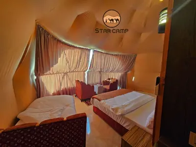 a room with two beds and a sign on the wall at Star Camp in Wadi Rum