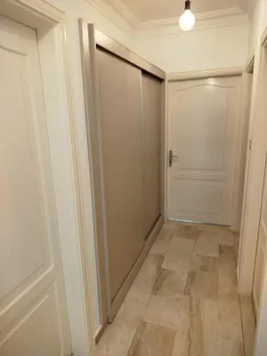 a hallway with a sliding door and a tile floor at Executive Apartments in Amman