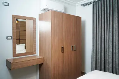 a wooden cabinet with a mirror in a bedroom at flamingo hotel irbid in Zabdah