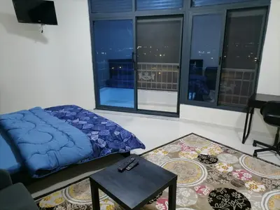 a living room with a blue bed and a table at For Women Only - للنساء فقط in Umm el ‘Amad