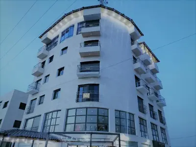 a tall white building with a lot of windows at Durrat Al Israa in Umm el ‘Amad
