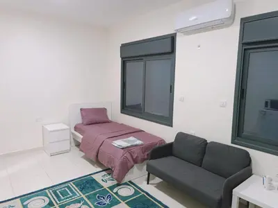 a living room with a bed and a couch at Durrat Al Israa in Umm el ‘Amad