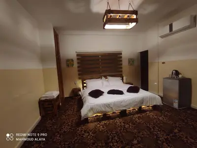 a bedroom with a bed with two cats laying on it at Petra Wooden House in Wadi Musa