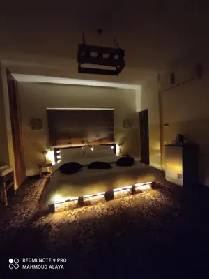 a bedroom with a large bed with lights on it at Petra Wooden House in Wadi Musa