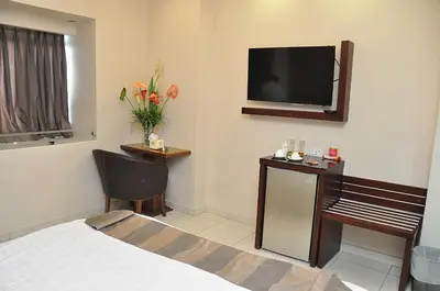 a hotel room with a bed and a flat screen tv at Bashtamal Hotel Suites in Amman