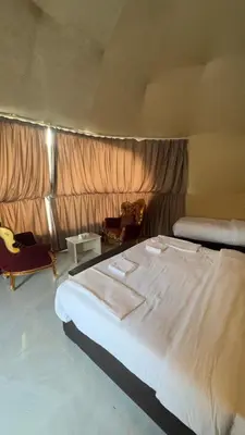 a bedroom with a large white bed in a room at Rehana rum luxury camp in Wadi Rum