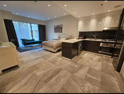 a bedroom with a bed and a kitchen with a sink at Luxury Studio DAMAC TOWER - 1 BEDROOM -JORDAN in Amman