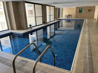 a large pool with blue water in a building at Luxury Studio DAMAC TOWER - 1 BEDROOM -JORDAN in Amman