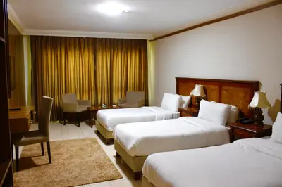 a hotel room with two beds and a desk at Amman Orchid Hotel in Amman