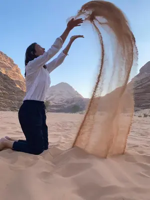 a woman standing in the sand in the desert at Wadi Rum albasli in Wadi Rum