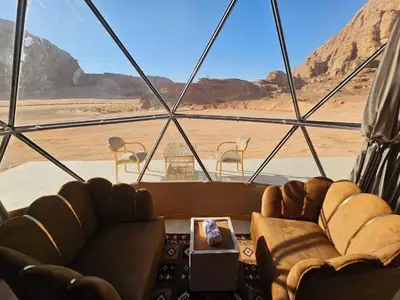 a room with two couches and a view of the desert at Wadi Rum Oscar camp in Wadi Rum