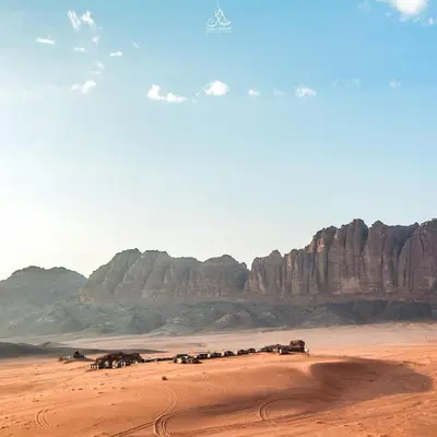 a herd of animals in a desert with mountains at Art Camp Wadi Rum in Wadi Rum