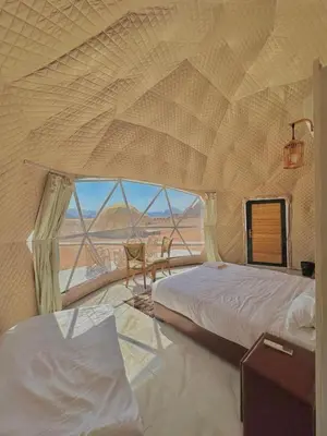 a bedroom with two beds and a view of the desert at Sun rise wadi rum camp in Wadi Rum