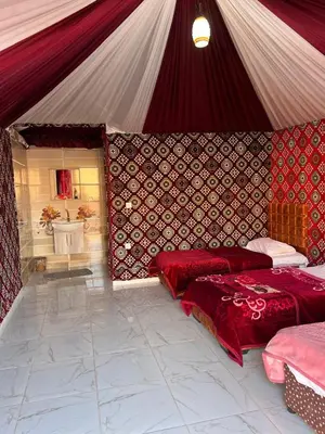 a room with two beds in a tent at Wadi Rum Story Camp in Wadi Rum