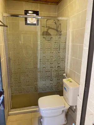 a bathroom with a toilet and a glass shower at Wadi Rum Story Camp in Wadi Rum