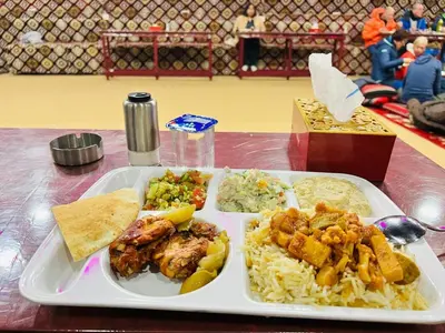 a plate of food with rice and meat and vegetables at Wadi Rum Story Camp in Wadi Rum