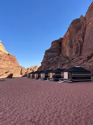 a group of buildings in a desert with mountains at Wadi Rum Story Camp in Wadi Rum