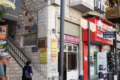 a man walking down a street next to a building at فندق الريفييرا in Ash Shumaysānī
