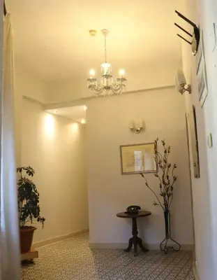 a hallway with a table and a chandelier at فندق الريفييرا in Ash Shumaysānī