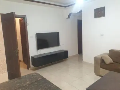 a living room with a flat screen tv on a wall at شقة مفروشة فرش فاخر ٣ غرف نوم في طبربور عمان in Amman