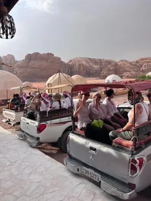 a group of people riding in the back of a jeep at Orbit camp in Wadi Rum