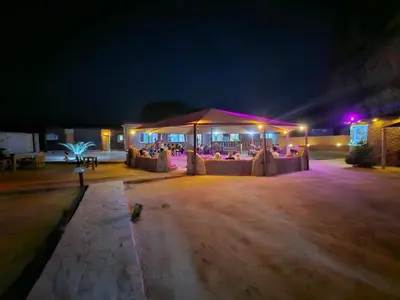 a marquee with tables and chairs at night at Orbit camp in Wadi Rum