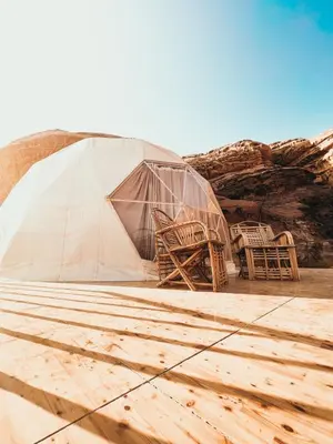 a marquee with chairs and a tent in the desert at Orbit camp in Wadi Rum
