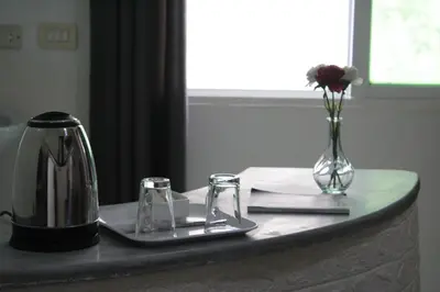 a table with a tea kettle and a vase of flowers at VALUE PLACE in Wadi Musa