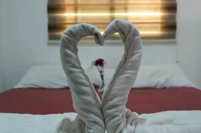 a pair of hands forming a heart on a bed at VALUE PLACE in Wadi Musa