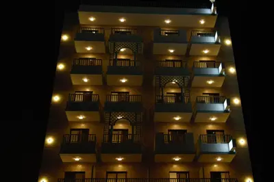 a tall building with a lit up facade at night at Turquoise Hotel in Aqaba