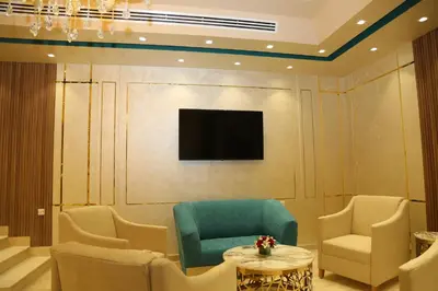 a room with a tv and chairs and a table at Turquoise Hotel in Aqaba
