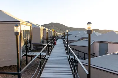 a long walkway leading to a row of houses at The Rock Camp Petra in Wadi Musa