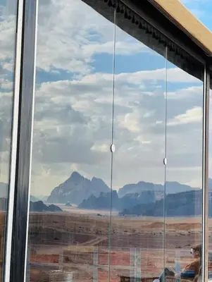 a window with a view of the desert and mountains at Rum Aranda camp &Bubbles Hotel in Wadi Rum