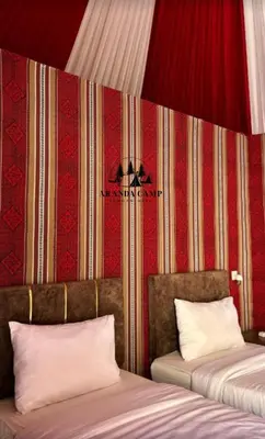 a room with two beds and a red wall at Rum Aranda camp &Bubbles Hotel in Wadi Rum