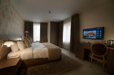 a hotel room with a bed and a tv at Khan Khediwe Hotel in Amman