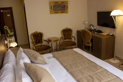a hotel room with a bed and a desk and chairs at Khan Khediwe Hotel in Amman