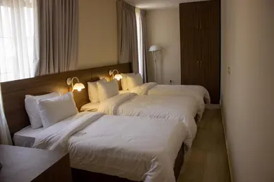 two beds in a hotel room with white sheets at Khan Khediwe Hotel in Amman