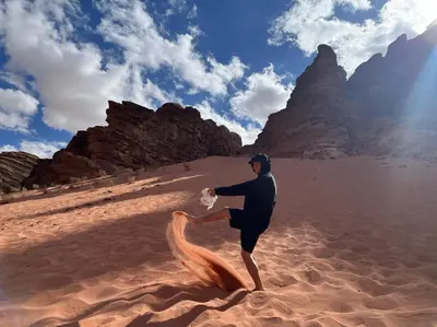 a man in a wet suit standing on a beach at wadi rum land mars in Wadi Rum