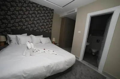 a bedroom with a bed with a teddy bear on it at فندق صحارى الخليج Sahara Gulf Hotel Apartments in Amman