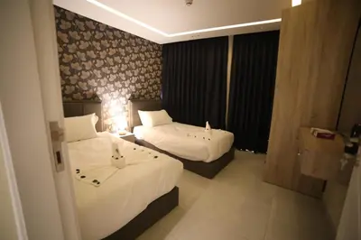 a hotel room with two beds and a window at فندق صحارى الخليج Sahara Gulf Hotel Apartments in Amman